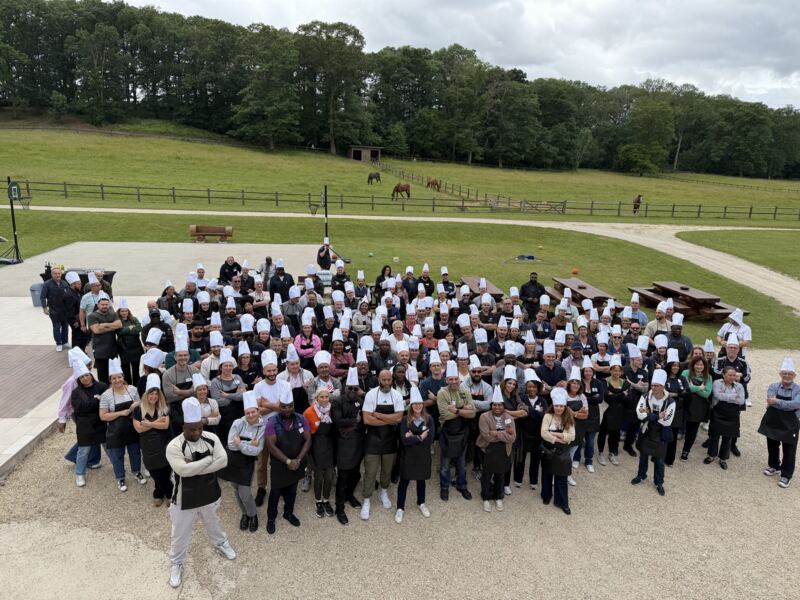 Photo de groupe de plus de cent collaborateurs en toque après un team building culinaire