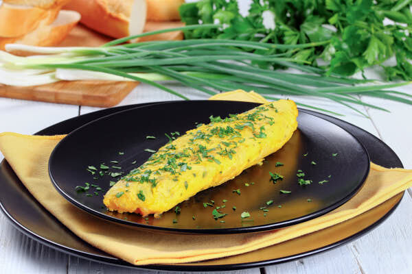 Omelette roulée de forme ovale dressée dans une assiette