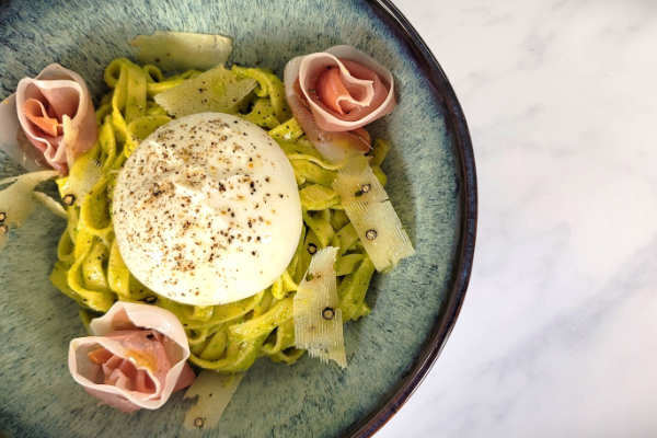 Assiette de tagliatelles au pesto de pistache avec burrata et chiffonnade de speck