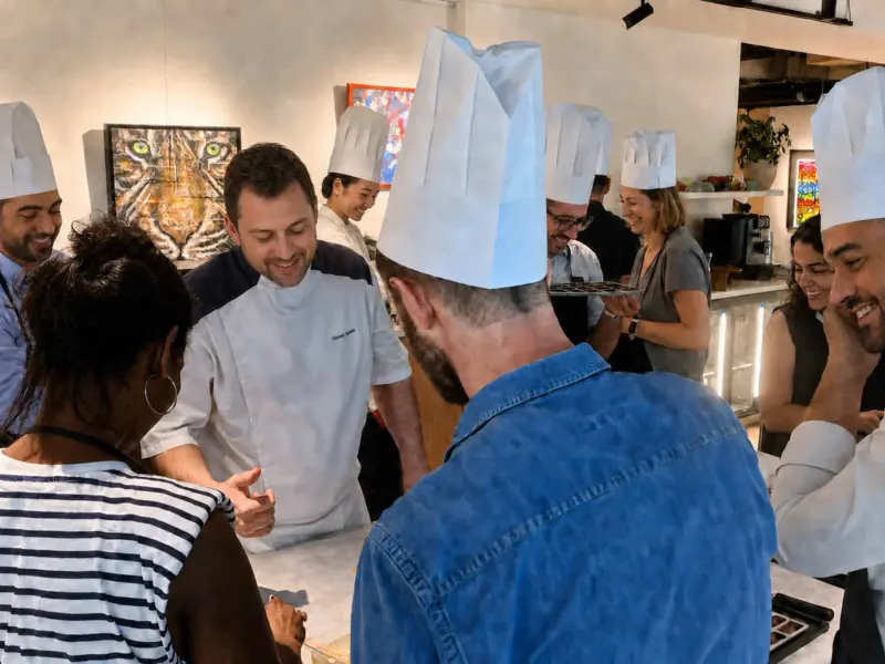 Chef souriant expliquant la recette à des participants en toque