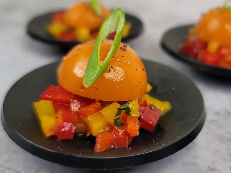 Dôme orange de gaspacho andalou sur brunoise de poivrons et basilic