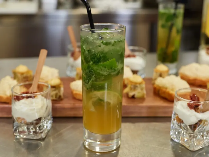 Cocktail mojito frais entouré de canapés et verrines gourmandes