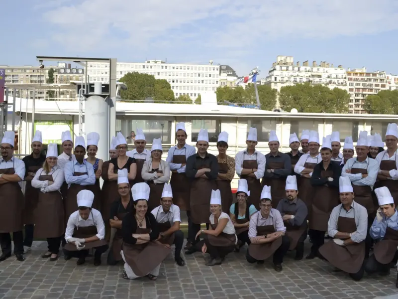 Grand groupe en tabliers et toques posant en extérieur à Paris