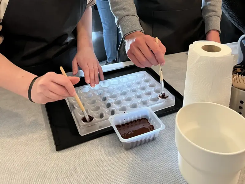 Participants garnissant un moule à chocolat au pinceau
