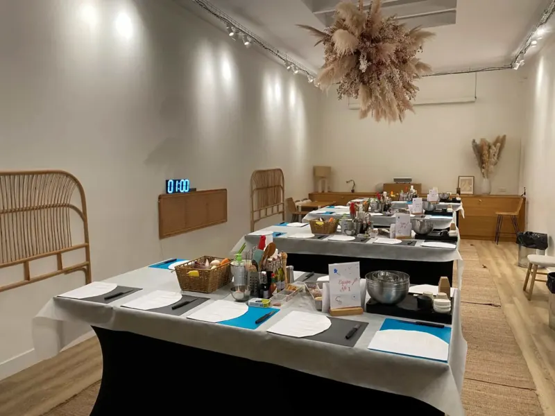 Salle dressée avec tables, plans bleus et minuteur affichant une heure