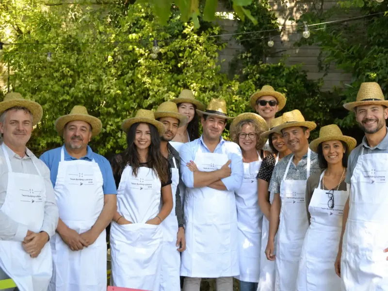 Groupe souriant en tabliers et chapeaux de paille au jardin