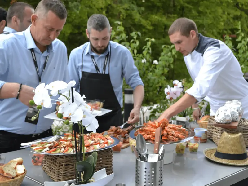 Participants se servant au buffet de fruits de mer en plein air