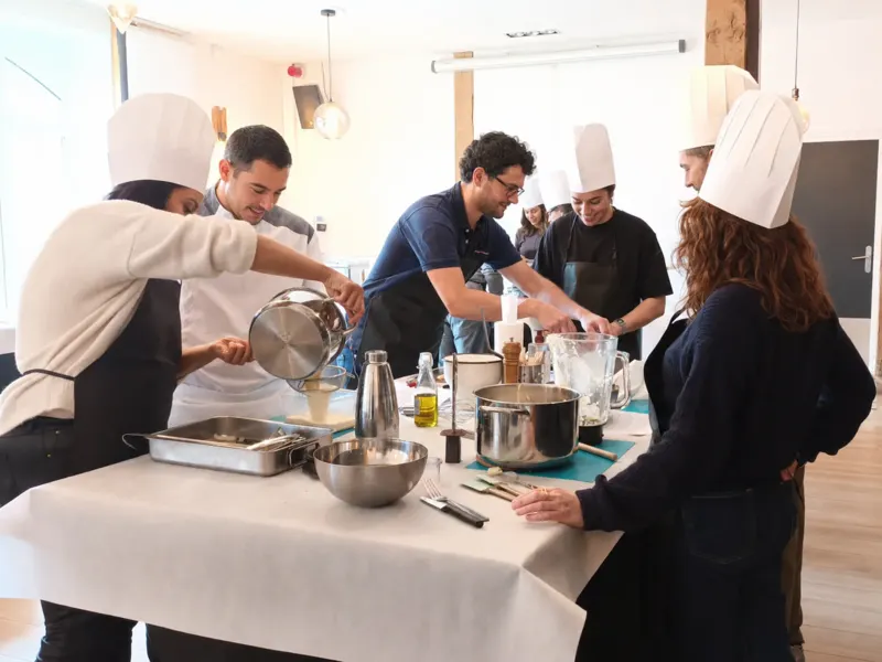 Équipe en toques dressant des macarons autour du chef