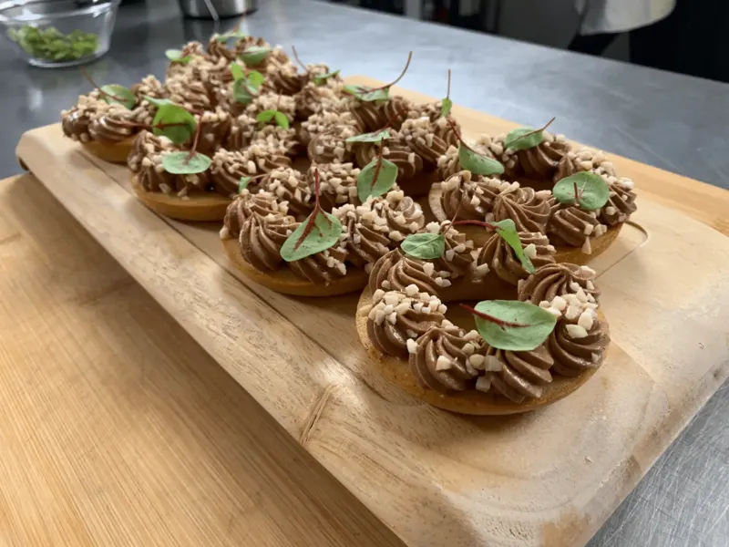 Financiers au chocolat garnis d'éclats de noisettes sur planche en bois