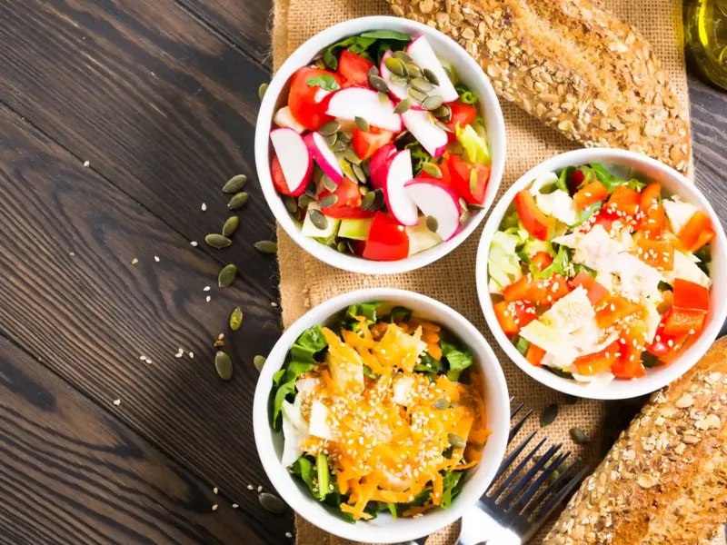 Trois bols de crudités colorées avec pain aux graines