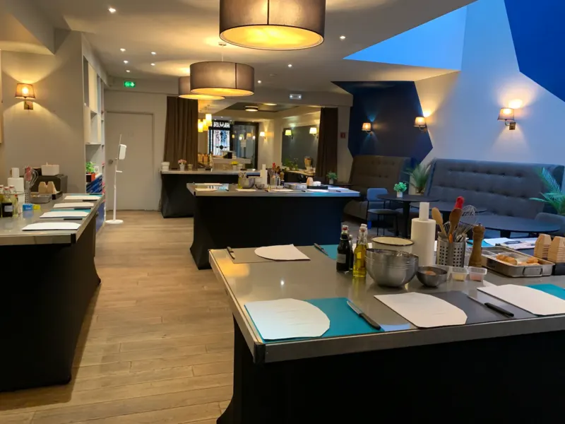 Salle d'atelier culinaire avec plans de travail dressés