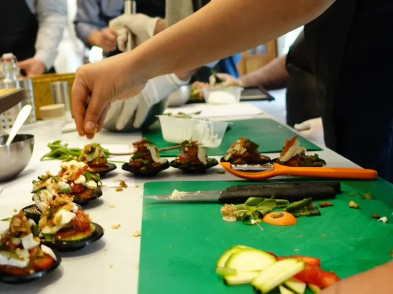 Mains dressant des bouchées apéritives sur planche verte