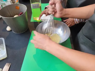 Les participants en train de préparer la mayonnaise pour la Tortilla aux oignons et chorizo, aïoli maison