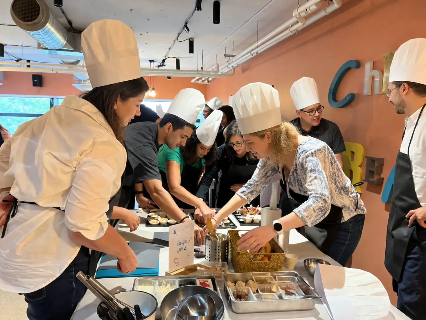 Une équipe en plein atelier culinaire, guidée par le chef